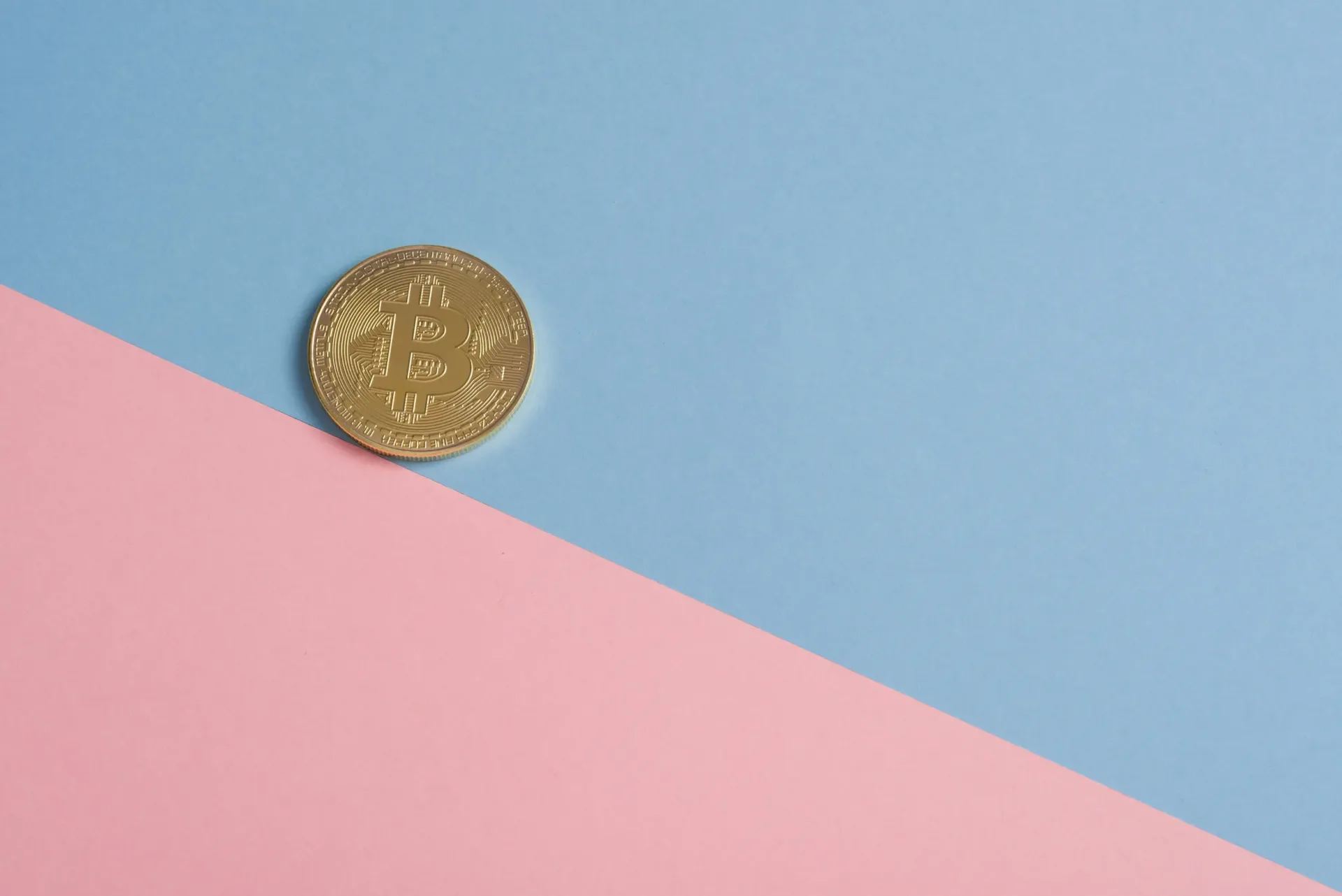 Hình ảnh mô tả 1 đồng bitcoin trên nền xanh và hồng